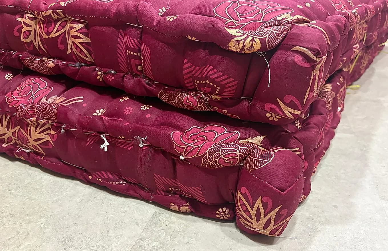 मोटे बॉक्स्ड-एज मैट्रेस का स्टैक जिसमें मजबूत साइडवॉल सिलाई दिखती है